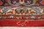 Woven signature cartouche in the red end field above ivory and navy floral borders