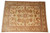 Full overhead photograph of ivory gold Oriental rug with palmettes, vines and multiple decorative borders
