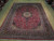 9'9" x 12'8" Kashan rug laid flat on wood floor showing full medallion and borders