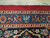 Woven signature cartouche set in the blue outer border above navy floral guard stripe