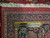 Back of the hand-knotted wool rug beside a ruler showing fine knot density