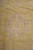 Macro detail of pastel palmette and rosette motifs woven in beige on golden wheat ground