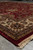 9 by 12 wool rug corner at low angle with cream fringe over grey tile floor