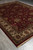 9x12 Indian hand-knotted rug on tile floor showing traditional red field and ivory floral border