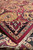 Burgundy field and black border with corner turned back to show knot density