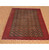 Angled room view of the 9'7" x 12'6" Turkmen rug on wood floor under warmer lighting