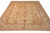 Angled view of the 9' x 12'5" hand-knotted wool rug showing beige field and rust borders