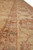 Perspective along the inner border stripe showing scrolling vine work in terracotta and soft brown
