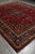 Angled full-length view of the 9'7" x 12' Persian Mashad rug on grey floor