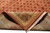 Folded corner reveals dense wool pile, Greek key border and ivory cotton fringe