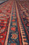 Border stripes close-up showing the teal guard band with rose blossoms on hand-knotted wool