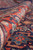 Rolled edge showing thick wool pile depth with red border meeting the navy ground
