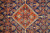 Close-up of rust-orange diamond medallion with ivory zigzag outline, teal rosettes and navy fish motifs