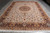 Large ivory room size oriental rug photographed lengthwise showing fringe, medallion and wide border