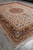 Full 10x14 Turkish Tabriz design rug angled on grey floor with fringed end visible