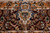 Close detail of burgundy border cartouche with blue arabesque scrollwork and green leaf sprays