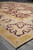 Corner perspective of beige main border with burgundy palmettes and gold guard stripe