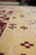 Close-up of gold inner stripe dotted with small burgundy cross motifs in wool