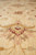 Close-up of a pink and rust palmette blossom woven into the soft cream wool pile