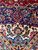 Corner detail showing navy spandrel, ivory border and pink palmettes in dense hand-knotted wool pile