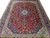 Large 9'8" x 13' Kashan rug photographed flat, showing balanced medallion, spandrels and multiple navy floral borders