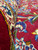 Thick wool pile curled back at the border, showing lustrous red yarn and crisp color separation