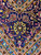 Navy border detail with ivory vine tracery, gold outlines and wine red palmettes in fine wool