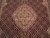 Close-up of salmon medallion surrounded by dense herati fish lattice on wine red field