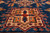 Coral star medallion with blue tree motifs woven into the deep navy blue field