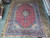 9'8 x 13'5 Persian Kashan rug photographed flat on showroom stone tile floor overhead