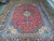 10x13 Persian Kashan rug shown full length with cream corner cartouches and navy blue border
