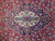 Close-up of ivory and indigo medallion with turquoise rosette on a red rug field