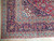 Corner detail showing light blue guard stripes, ivory fringe and palmette vines on indigo border
