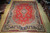 9'11" x 13'3" Persian Sarouk rug lying flat on a light wood showroom floor