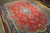 Low perspective across the tomato red field, scattered flower sprays and deep navy center medallion