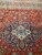 Navy stepped medallion with ivory cartouche and turquoise center rosette on red Persian rug