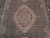 Close-up of blush diamond medallion surrounded by tiny ivory rosettes on deep black Herati field