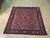 Hand-knotted wool Sarouk rug showing all-over diamond panel repeat across a salmon red ground