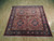 Full view of 7x7 square Persian rug with cream leaf outlines and burgundy guard stripes