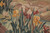 Iris blossoms in gold, burgundy and ivory woven against a soft mauve hillside background