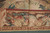 Lower border detail with reclining cherub, grapes and basket weave guard stripe, soft storage crease