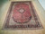 9'8" x 13'4" Persian Kashan rug displayed on light wood floor showing complete floral design