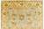 Corner detail of ivory border with rust rosettes, scrolling vines and striped guard stripes beside blue field