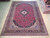 9'10" x 13' Persian Kashan rug displayed full length on pale hardwood showroom floor