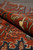 Rolled edge of the hand-knotted rug showing dense pile height and crisp ivory outlines