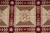 Detail of a single ivory panel framed by burgundy laurel bands and cream rosette