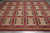 9 x 11'8" needlepoint flat weave rug viewed overhead with cream rosettes on olive squares
