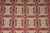 Close detail of ivory rosettes, olive triangles and gold laurel sprigs across the panel field