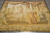 Overhead view of the hand-woven wool and silk tapestry laid flat on grey tile flooring