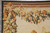 Corner detail with lion mask, ribbon and cascading fruit garland on an ivory ground